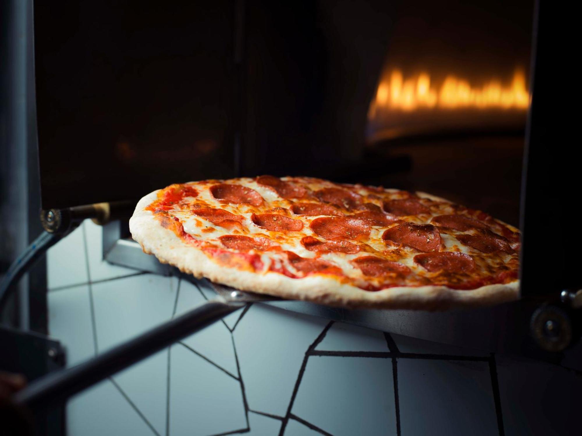 Sheraton Dammam Hotel & Convention Centre Extérieur photo Pizza being removed from a wood-fired oven